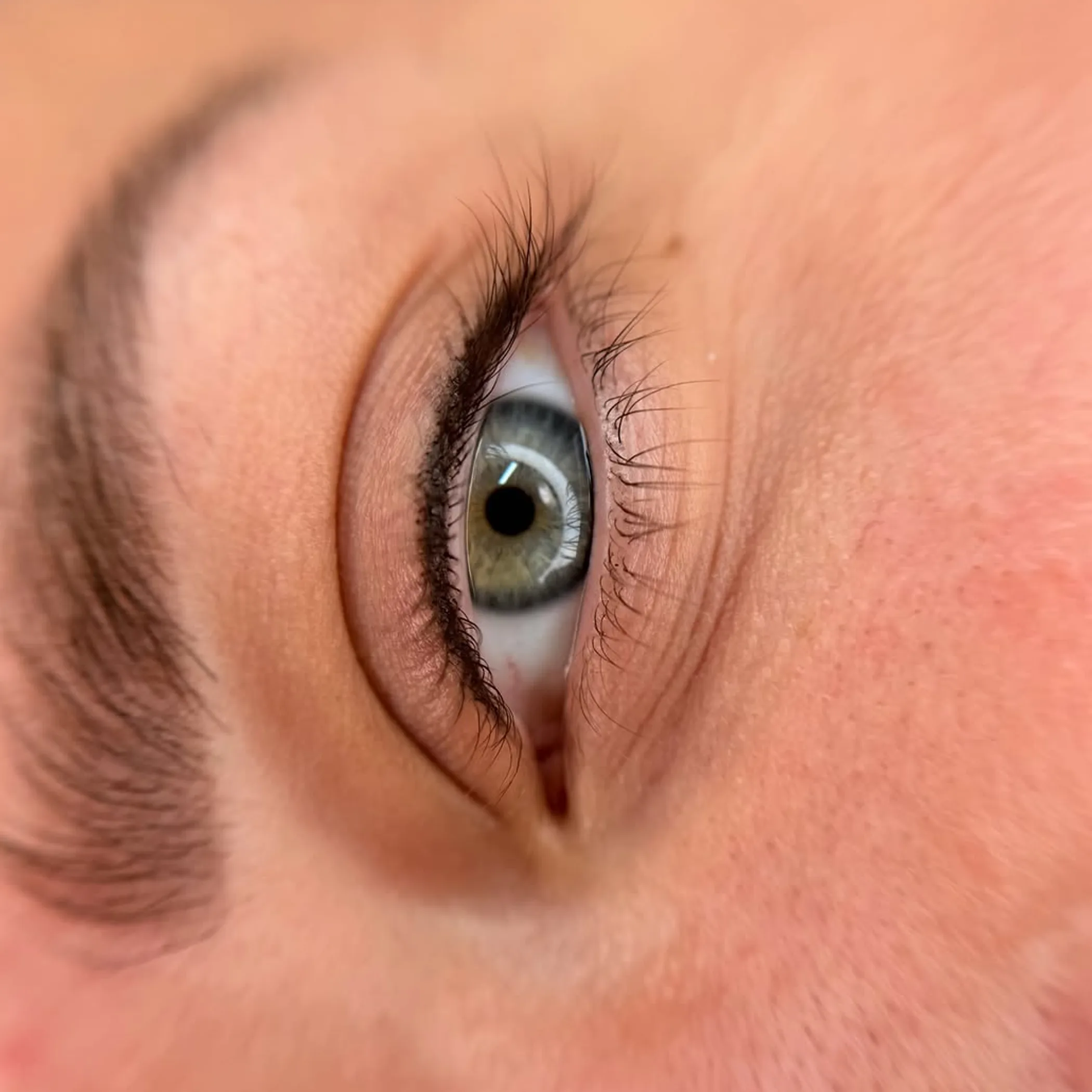 technician applying pigment to upper lash line man